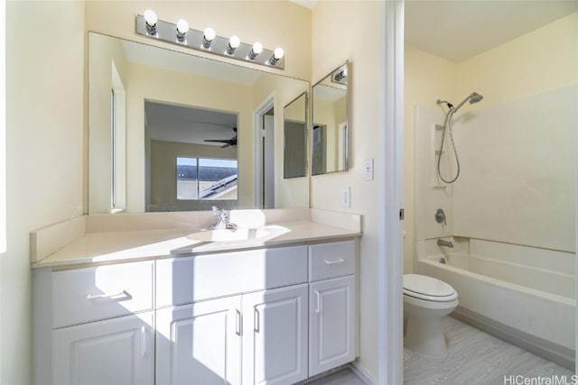 full bathroom with toilet, hardwood / wood-style floors, shower / bathing tub combination, vanity, and ceiling fan