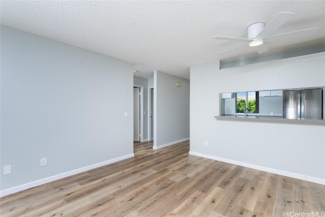 spare room featuring ceiling fan, sink, a textured ceiling, and light wood-type flooring