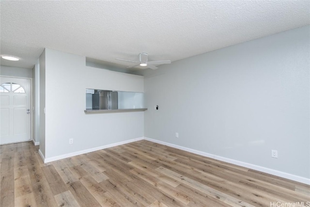 unfurnished room with light hardwood / wood-style floors, a textured ceiling, and ceiling fan