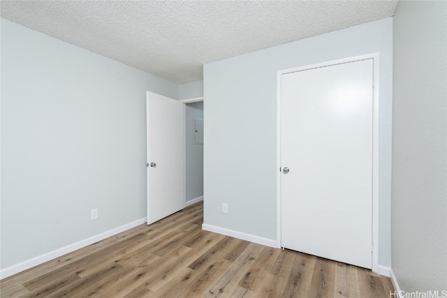 unfurnished bedroom with a textured ceiling and light hardwood / wood-style flooring