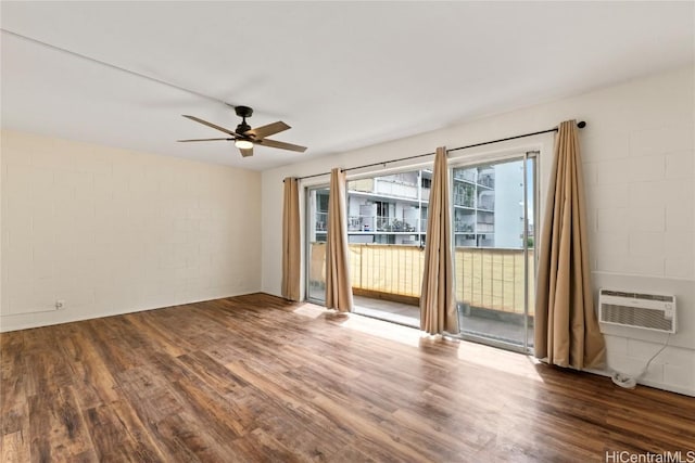 empty room with ceiling fan, hardwood / wood-style flooring, and a wall mounted AC