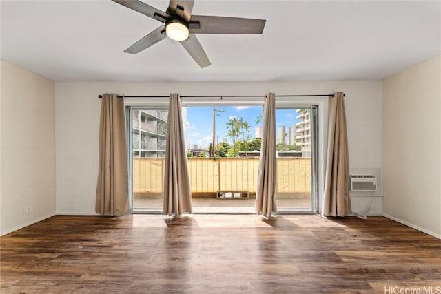 spare room featuring ceiling fan, plenty of natural light, dark hardwood / wood-style floors, and a wall unit AC