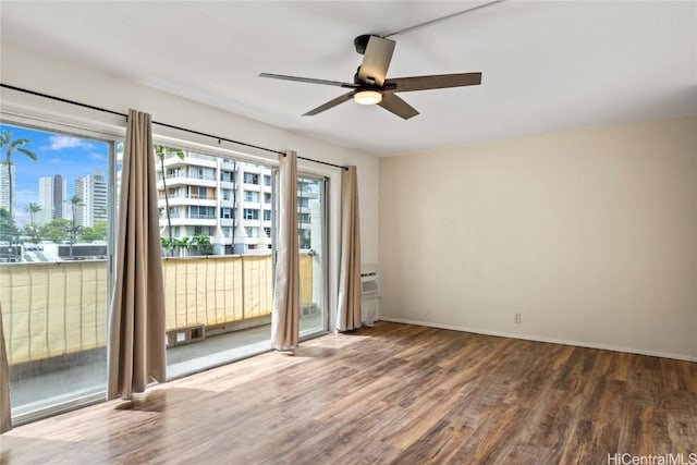 spare room with ceiling fan, plenty of natural light, and dark hardwood / wood-style flooring