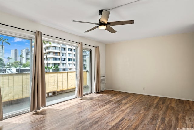 2875 S King St Unit 209, Honolulu, HI 96826 - unfurnished room with wood finished floors, ceiling fan, baseboards, and a city view
