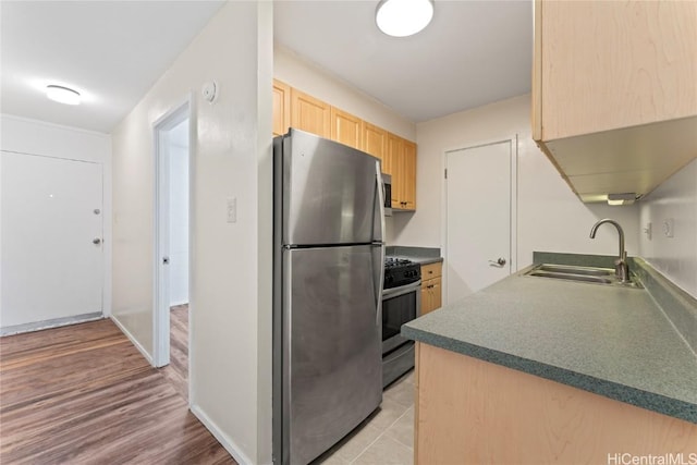 kitchen with stainless steel appliances, sink, and light brown cabinets