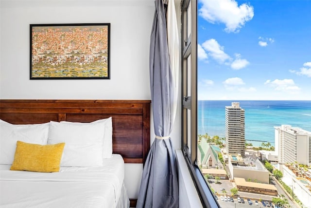 bedroom with multiple windows and a water view