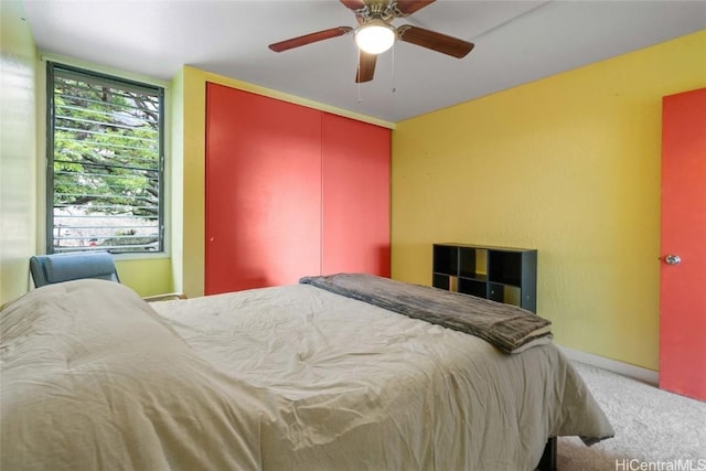 bedroom with ceiling fan, carpet floors, and a closet