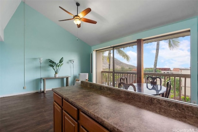 interior space featuring ceiling fan, dark hardwood / wood-style flooring, a mountain view, and vaulted ceiling