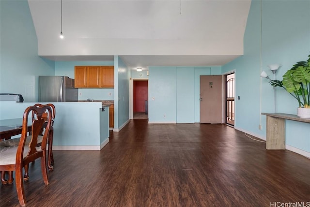 interior space with a towering ceiling and dark hardwood / wood-style flooring