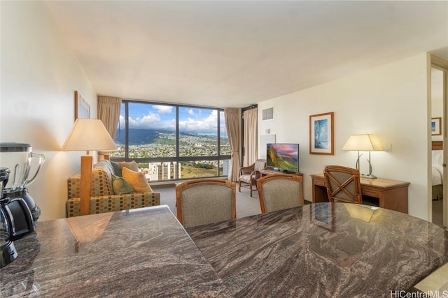 carpeted dining space with floor to ceiling windows