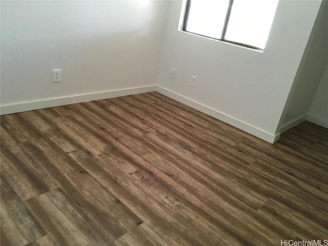 empty room with dark hardwood / wood-style flooring