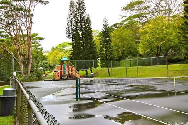 view of tennis court featuring a playground