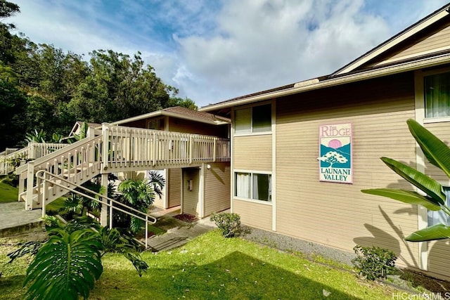 back of property featuring a lawn and a deck