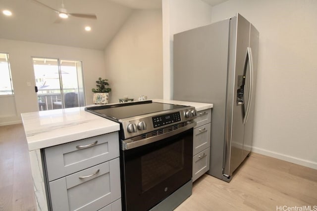 kitchen featuring ceiling fan, light hardwood / wood-style floors, lofted ceiling, stainless steel appliances, and gray cabinets