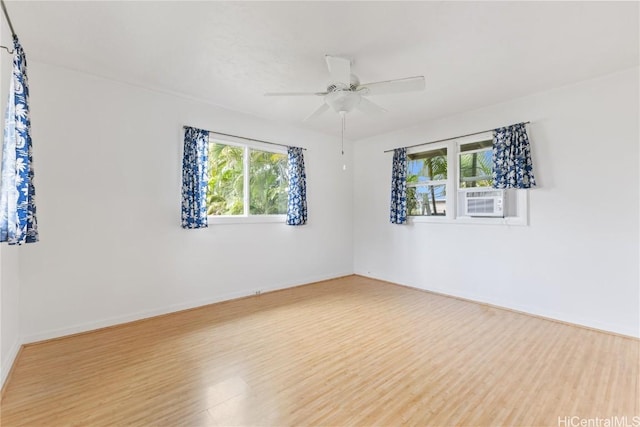 spare room featuring cooling unit, hardwood / wood-style flooring, and ceiling fan