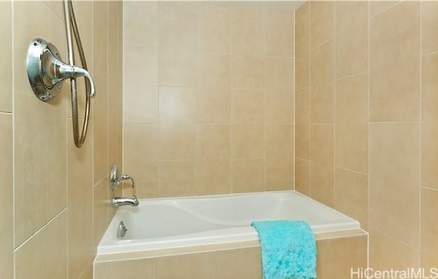 bathroom featuring tiled tub