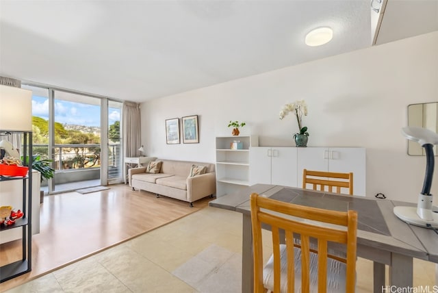 living area with a wall of windows and light tile patterned flooring