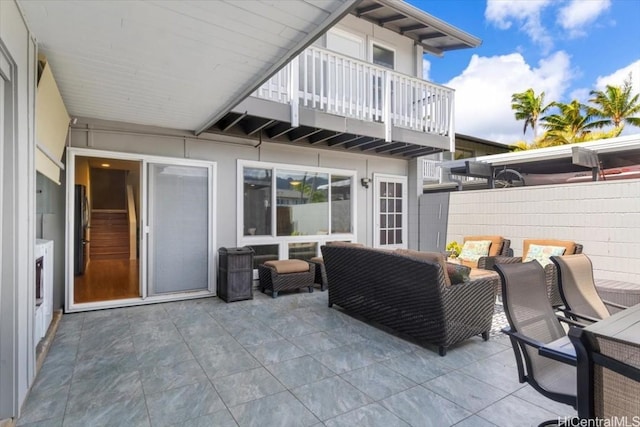 view of patio with an outdoor living space and a balcony