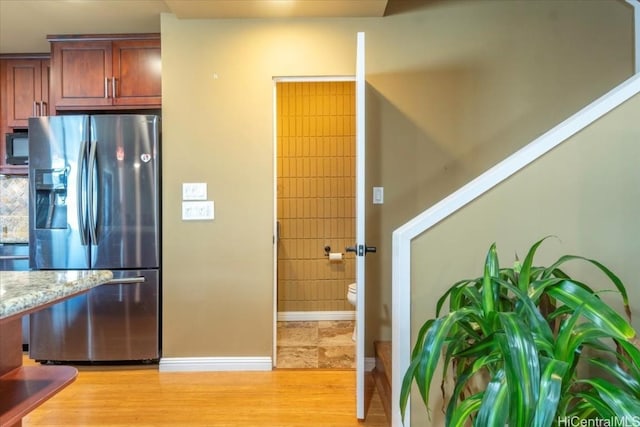 kitchen featuring stainless steel fridge and light hardwood / wood-style floors