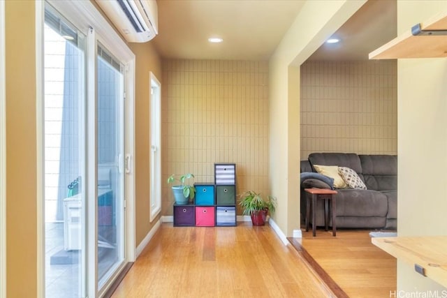 interior space featuring tile walls, wood-type flooring, and a wall mounted AC