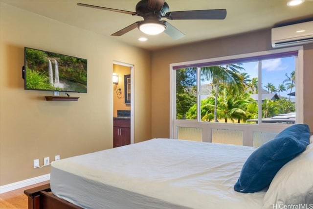 bedroom with hardwood / wood-style flooring, ceiling fan, ensuite bathroom, and an AC wall unit