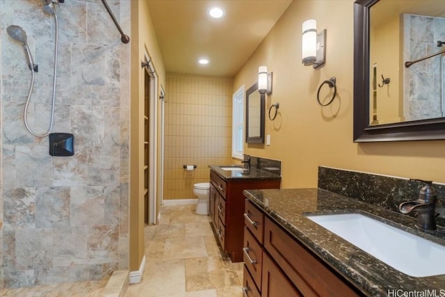 bathroom featuring tile walls, vanity, a shower, and toilet