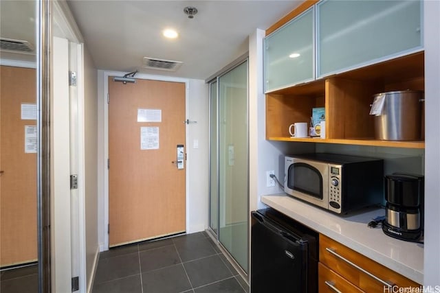 kitchen with refrigerator and dark tile patterned floors