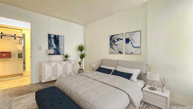 carpeted bedroom featuring a barn door