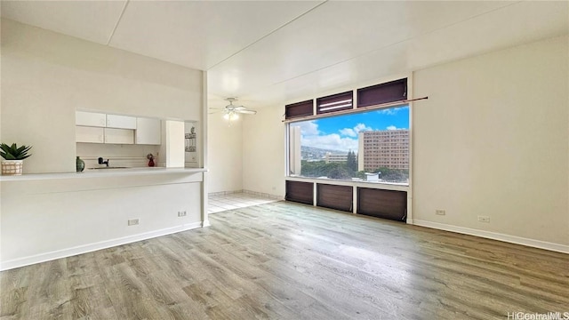 spare room with light hardwood / wood-style floors, sink, and ceiling fan