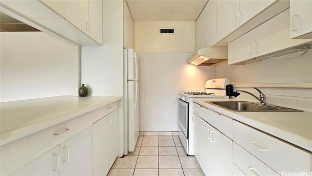 kitchen featuring sink, white appliances, white cabinets, and light tile patterned floors