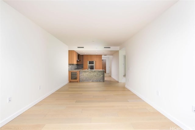 hall featuring beverage cooler and light hardwood / wood-style floors