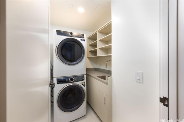 clothes washing area featuring stacked washer / dryer and sink