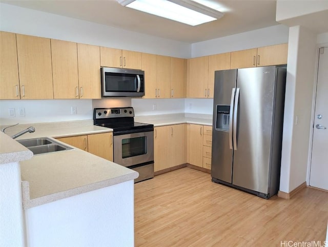 kitchen featuring stainless steel appliances, sink, light brown cabinets, and light hardwood / wood-style floors