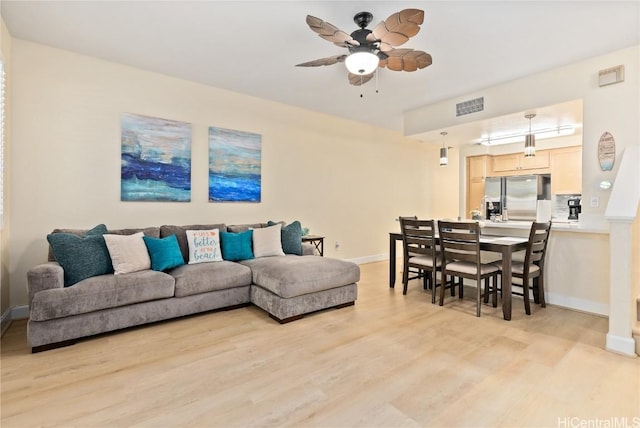 living room featuring light hardwood / wood-style floors and ceiling fan