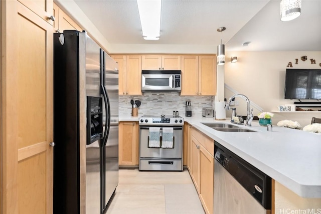 kitchen featuring pendant lighting, light brown cabinetry, sink, backsplash, and stainless steel appliances