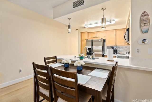 dining room featuring sink and light wood-type flooring