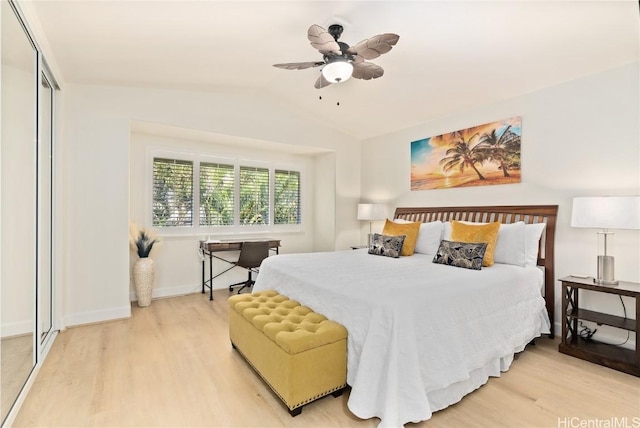 bedroom with vaulted ceiling, light wood-type flooring, ceiling fan, and a closet