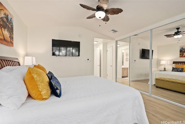 bedroom with lofted ceiling, hardwood / wood-style flooring, a closet, and ceiling fan