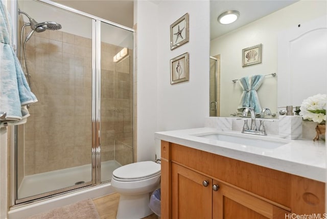 bathroom featuring vanity, toilet, and an enclosed shower