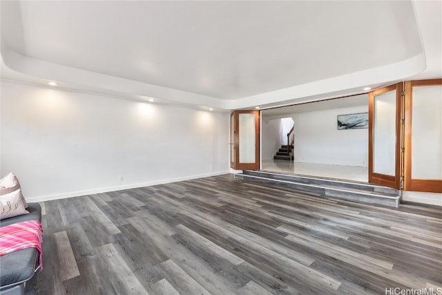 unfurnished living room with a tray ceiling and hardwood / wood-style flooring