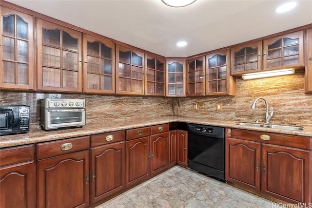 kitchen featuring light stone counters, sink, backsplash, and black appliances