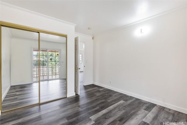 unfurnished room with ornamental molding and dark wood-type flooring