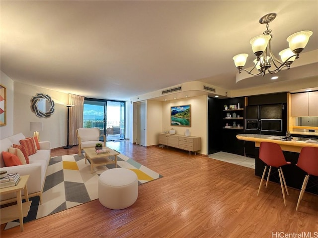 living room featuring a wall of windows, a chandelier, and light hardwood / wood-style floors