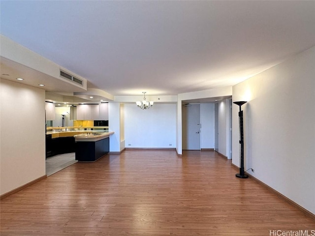 unfurnished living room featuring dark hardwood / wood-style flooring and a chandelier