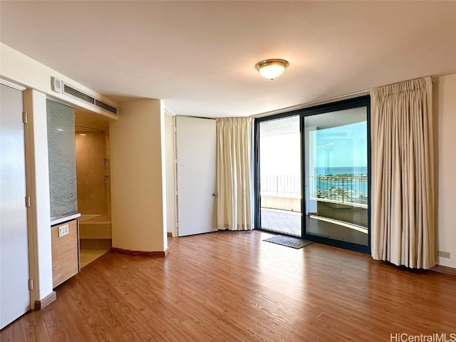 spare room with hardwood / wood-style flooring and expansive windows