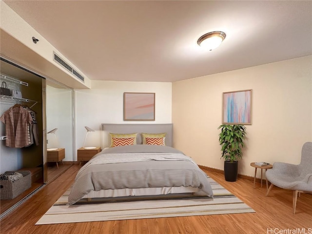 bedroom with hardwood / wood-style floors and a closet