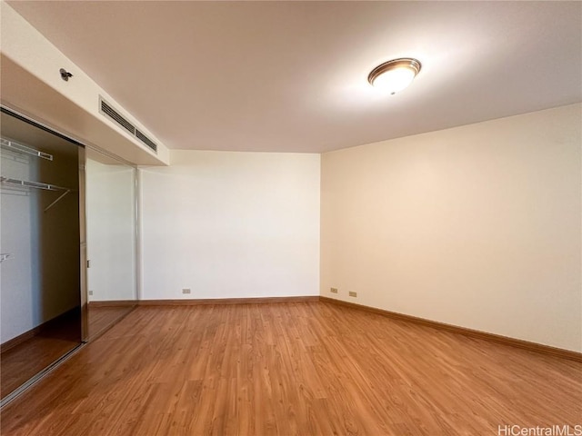 unfurnished bedroom with hardwood / wood-style flooring and a closet