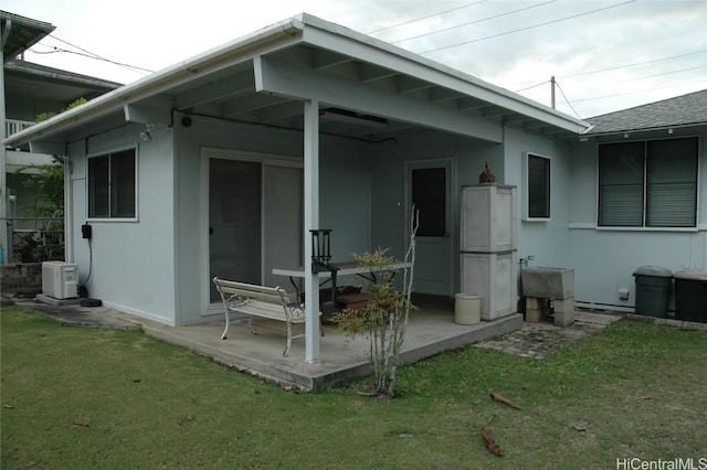 back of house with sink, a yard, and a patio area