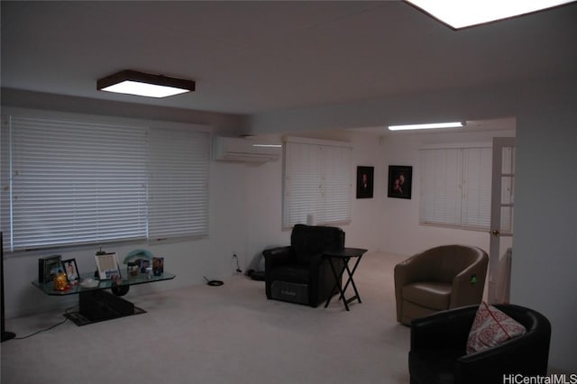 sitting room featuring an AC wall unit and carpet floors