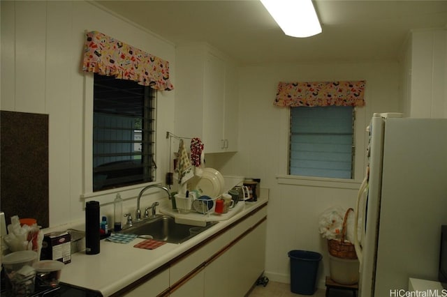 kitchen featuring sink, white fridge, and white cabinets